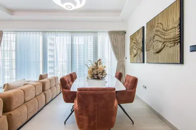 a dining room with a table and a couch at Me Do Re1BR, JLT in Dubai