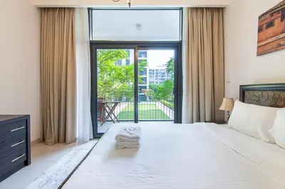 a bedroom with a large bed and a large window at Park Point 1 BR, Dubai Hills in Dubai