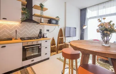 a kitchen with a wooden table and a dining room at Collective 1,0 Dubai Hills- Cozy 1-BR in Dubai