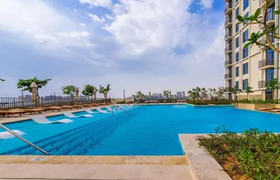 a large swimming pool with benches and a building at Collective 1,0 Dubai Hills- Cozy 1-BR in Dubai