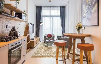 a kitchen and living room with a table and chairs at Collective 1,0 Dubai Hills- Cozy 1-BR in Dubai