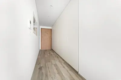 an empty hallway with white walls and wood floors at StoneTree - Newly Furnished - Stylish in Dubai