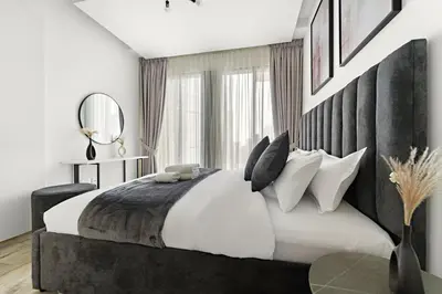 a bedroom with a large bed and a mirror at StoneTree - Newly Furnished - Stylish in Dubai