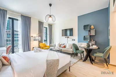 a bedroom with a bed and a living room at Exclusive Promo Luxe 1BR at a Special Price by Deluxe Holiday Homes in Dubai