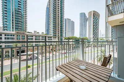 a balcony with a wooden table and a view of a city at Exclusive Promo Luxe 1BR at a Special Price by Deluxe Holiday Homes in Dubai