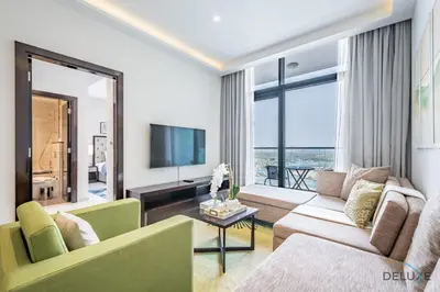 a living room with a couch and a tv at Cosmopolitan 1BR Apartment in Celestia B, Dubai South by Deluxe Holiday Homes in Dubai