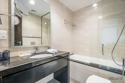 a bathroom with a sink and a shower and a tub at Cosmopolitan 1BR Apartment in Celestia B, Dubai South by Deluxe Holiday Homes in Dubai
