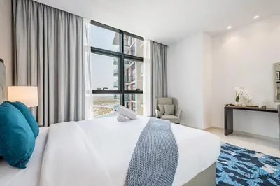 a bedroom with a white bed and a large window at Cosmopolitan 1BR Apartment in Celestia B, Dubai South by Deluxe Holiday Homes in Dubai