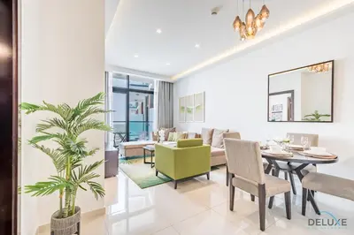 a dining room and living room with a table and chairs at Cosmopolitan 1BR Apartment in Celestia B, Dubai South by Deluxe Holiday Homes in Dubai