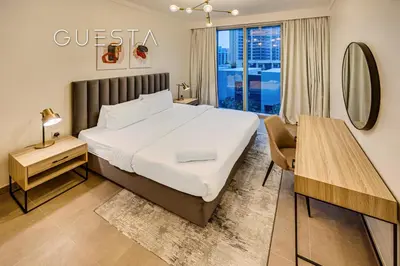 a bedroom with a bed and a table and a mirror at Creek Gate by Emaar, Dubai Creek Harbour in Dubai