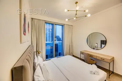 a bedroom with a bed and a desk and a mirror at Creek Gate by Emaar, Dubai Creek Harbour in Dubai