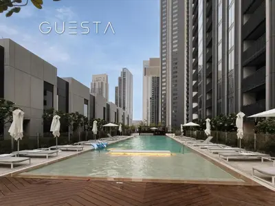 a swimming pool with lounge chairs and umbrellas at Creek Gate by Emaar, Dubai Creek Harbour in Dubai