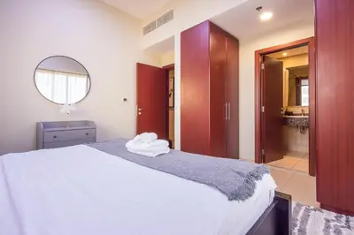 a bedroom with a large bed with a mirror at Two-Bedroom Apartment with Balcony in Shams 4, JBR in Dubai