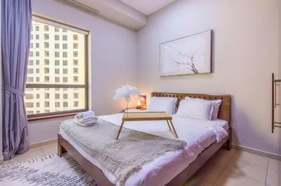 a bedroom with a bed with a table on it at Two-Bedroom Apartment with Balcony in Shams 4, JBR in Dubai