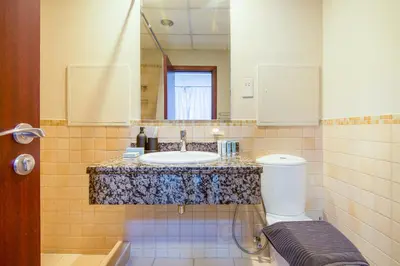 a bathroom with a sink and a toilet and a mirror at Two-Bedroom Apartment with Balcony in Shams 4, JBR in Dubai