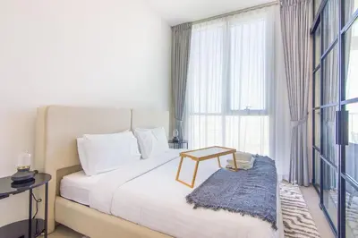 a bedroom with a bed with a table and a window at Collective 2,0 Dubai Hills- Attractive 1-BR in Dubai