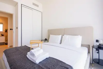 a bedroom with a large white bed and a table at Collective 2,0 Dubai Hills- Attractive 1-BR in Dubai