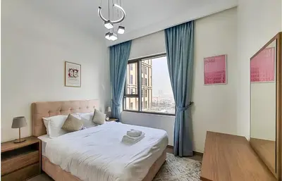 a bedroom with a bed and a large window at Park Heights, Dubai Hills- Cozy 1-BR in Dubai