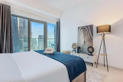 a bedroom with a bed and a large window at Prival - Marina & Sea View in Dubai