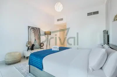 a white bedroom with a bed and a table at Prival - Marina & Sea View in Dubai