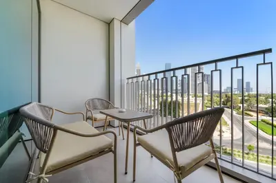 a balcony with chairs and a table and a view of the city at Chic 1BR Retreat - Near Burj Khalifa & Dubai Mall in Dubai