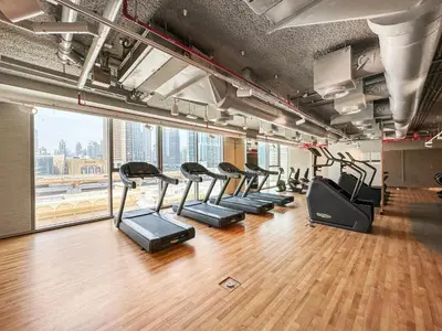 a gym with a row of treadmills at Chic 1BR Retreat - Near Burj Khalifa & Dubai Mall in Dubai