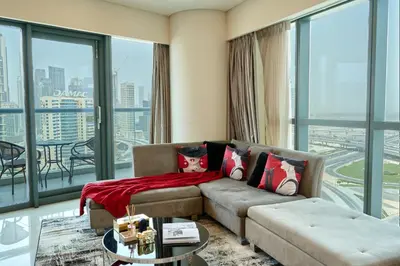 a living room with a couch and a large window at Luxurious 2BDR Apartment in Paramount Towers with Burj Khalifa Views in Dubai