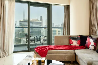 a living room with a couch and a large window at Luxurious 2BDR Apartment in Paramount Towers with Burj Khalifa Views in Dubai