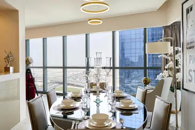 a dining room with a table and chairs and a large window at Luxurious 2BDR Apartment in Paramount Towers with Burj Khalifa Views in Dubai