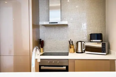 a kitchen with a counter top with a microwave at Luxurious 2BDR Apartment in Paramount Towers with Burj Khalifa Views in Dubai