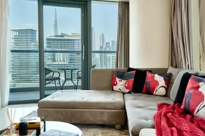 a living room with a couch and a large window at Luxurious 2BDR Apartment in Paramount Towers with Burj Khalifa Views in Dubai