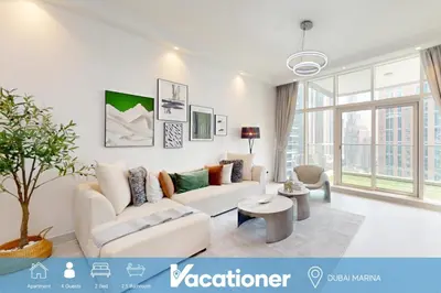 a white living room with a couch and a table at Marinascape Oceanic - Luxurious Two Bedroom in Dubai