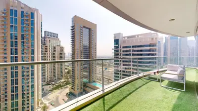 a balcony with a chair and a view of a city at Marinascape Oceanic - Luxurious Two Bedroom in Dubai