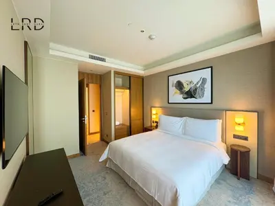 a bedroom with a large white bed and a table at Luxurious 2BR The Address Opera in Dubai