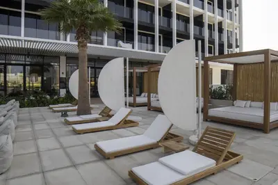 a row of chaise lounges and chairs on a patio at Modern Studio at Upside Living, Business Bay with Burj Khalifa View in Dubai