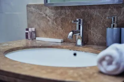 a bathroom sink with two faucets on a counter at Stunning Luxury Studio Downtown 2 Minute Walk to Burj Khalifa & Dubai Mall in Dubai