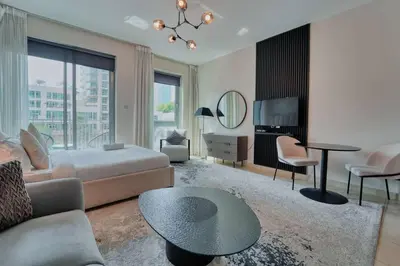 a living room with a bed and a table at Stunning Luxury Studio Downtown 2 Minute Walk to Burj Khalifa & Dubai Mall in Dubai