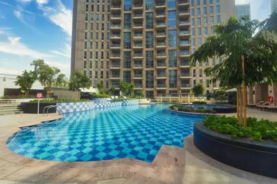 a large blue swimming pool in front of a tall building at Stunning Luxury Studio Downtown 2 Minute Walk to Burj Khalifa & Dubai Mall in Dubai