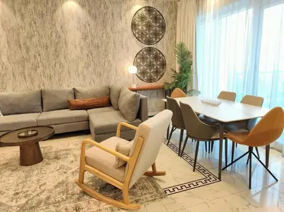 a living room with a couch and a table and chairs at Large 1BR with Great View in Dubai
