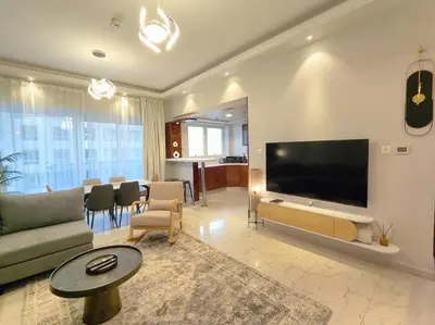 a living room with a large flat screen tv at Large 1BR with Great View in Dubai