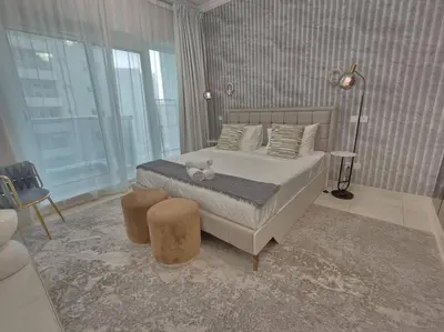 a bedroom with a bed with a teddy bear on it at Large 1BR with Great View in Dubai
