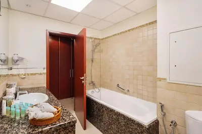 a bathroom with a tub and a sink and a tub and a toilet at Luxury 1 bedroom apartment in JBR with Beach access in Dubai