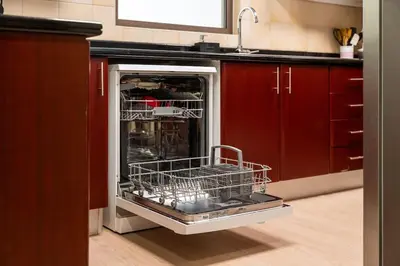 an open dishwasher in a kitchen with red cabinets at Luxury 1 bedroom apartment in JBR with Beach access in Dubai