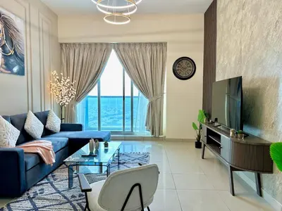 a living room with a blue couch and a tv at Skyline View Premium Apartment in Dubai