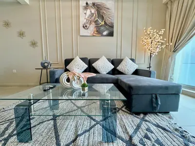 a living room with a couch and a glass table at Skyline View Premium Apartment in Dubai