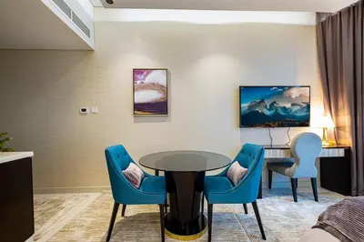 a room with a table and chairs and a desk at Stylish Studio in Heart Downtown Next Dubai Mall in Dubai