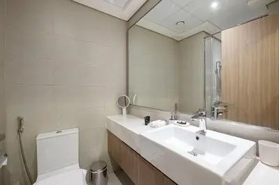a bathroom with a sink and a toilet and a mirror at Elegant Studio with Terrace 7 min Burj Khalifa in Dubai