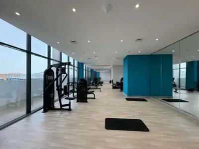 a gym with tread machines in a building with windows at Elegant Studio with Terrace 7 min Burj Khalifa in Dubai
