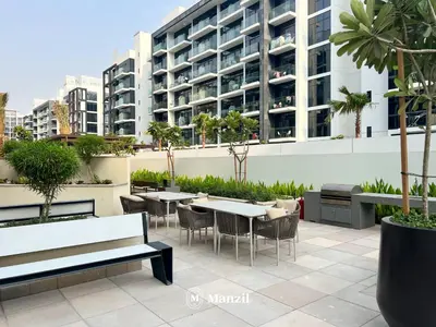 a patio with tables and chairs in front of a building at Manzil - Studio Apartment in Azizi Riviera near Dubai Mall in Dubai