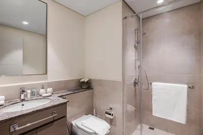 a bathroom with a shower and a toilet and a sink at 1BR Forte II Downtown View in Dubai